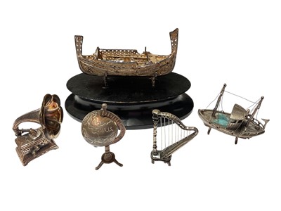 Lot 220 - Group of novelty miniature silver ornaments to include a harp, globe, gramophone and two boats, all at 3.6ozs (5).