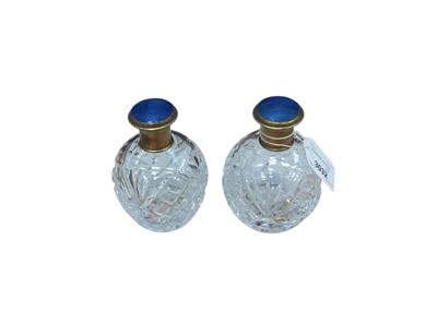 Lot 3032 - A pair of cut glass scent bottles with blue enamel tops