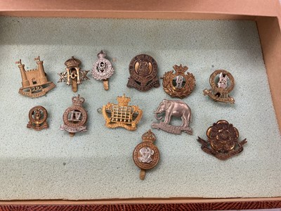 Lot 761 - Collection of fifty plus British Military cap badges to include Royal Armoured Corps, Artists Rifles and Tank Corps, housed in a four draw display cabinet.