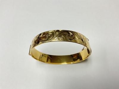 Lot 135 - Vintage rolled gold bangle with engraved foliate scroll decoration