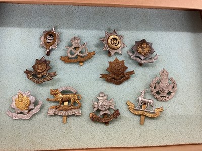 Lot 763 - Collection of seventy plus British Military cap badges to include The Norfolk Regiment, 2nd Hampshire Rifle Volunteers and The Essex Regiment, housed in a four draw display cabinet.