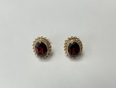 Lot 203 - Pair of 9ct gold garnet stud earrings, each with an oval mixed cut garnet in 9ct gold setting. 11.5mm