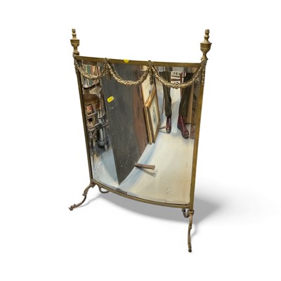 Lot 5345 - Edwardian brass and bowed bevelled mirror fire screen with swag and urn decoration on splayed legs