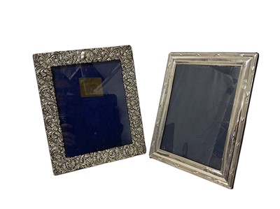 Lot 180 - Two silver photograph frames of rectangular form with easel supports, the first Edwardian floral and scroll design, Birmingham 1904, 27cm x 22cm overall, the second London 1992, 25cm x 19.5cm ov...