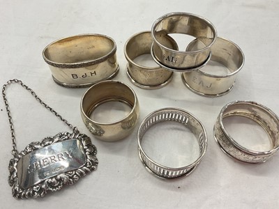 Lot 938 - Seven various silver napkin rings and a silver 'Sherry' label