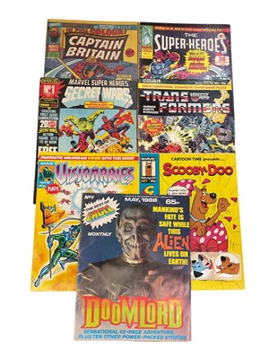 Lot 2895 - Marvel Comics The Transformers #1 1984 (with transfers) together with Marvel Super Heroes Secret Wars #1 1985 (with transfers), Captain Britain #3 1976, The Super-heroes #2 1975, Scooby-Doo #1 1...