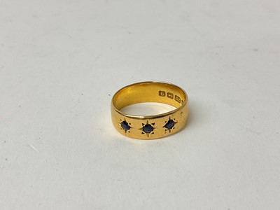 Lot 920 - 22ct gold ring with three mixed cut blue sapphires in star gypsy setting (Birmingham 1915)