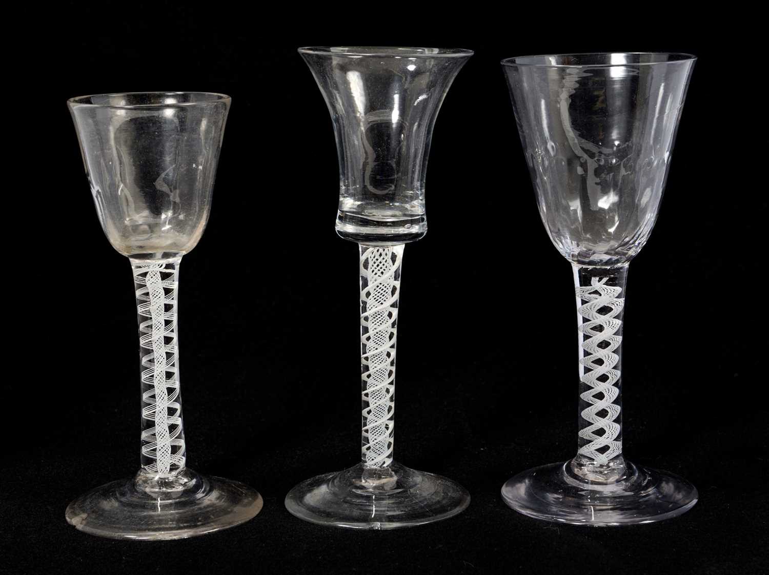 Lot 37 - Three Georgian opaque twist stem wine glasses, including two with fluted funnel bowls and one with bell shaped bowl, 13.75cm to 15cm high