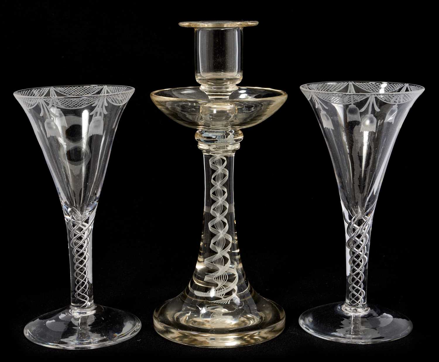 Lot 38 - A pair of 18th century style air twist wine glasses with etched swags, Bonhams label attached, 17.75cm high, together with an opaque twist stem candlestick, 23cm high, all probably continental...