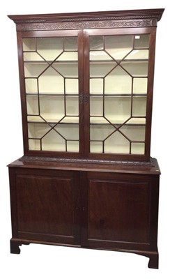Lot 1289 - Good quality 19th mahogany bookcase cabinet, the upper section with dentil cornice and blind fret carved frieze, enclosed by pair of astragal glazed doors, the base of twin panelled doors on car...