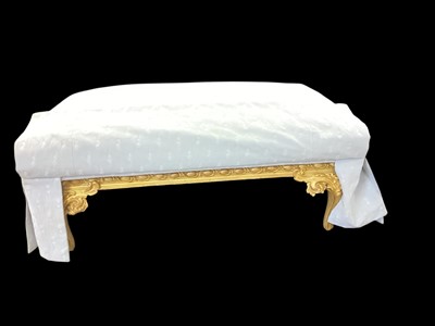 Lot 1408 - Antique carved and gilt painted rectangular footstool on foliate scroll supports, later upholstered in pattered blue fabric