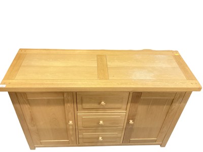 Lot 1309 - Contemporary light oak sideboard comprising central bank of three drawers, flanked each side by a panelled door.