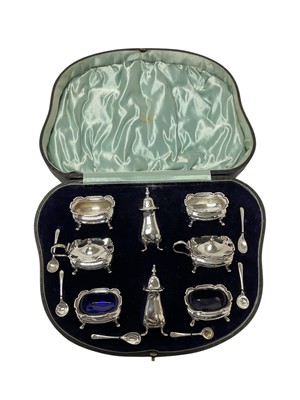 Lot 210 - Edwardian silver eight piece condiment set, comprising four salts, two with blue glass liners