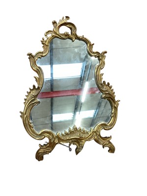 Lot 1320 - Large 19th century gilt brass table mirror, the heavy Rococo frame with a shaped plate, easel support