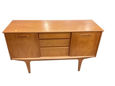 Lot 1387 - Mid century teak sideboard with three central drawers flanked by sliding doors, 127.5cm wide, 44.5cm deep, 74cm high