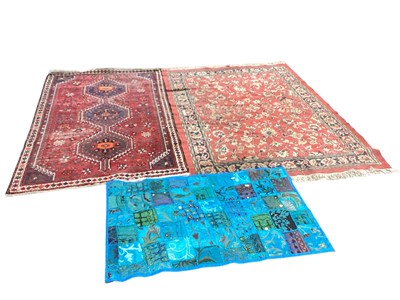 Lot 1401 - Eastern rug with three central medallions on red ground, 178cm x 109cm, together with another, 190cm x 138cm ans a wall hanging (3)