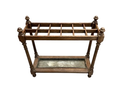 Lot 1467 - Large Edwardian oak country house stick stand, narrow rectangular form with twelve divisions, acorn finials and tin drip tray, 85cm wide x 32cm deep x 81cm high