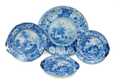Lot 99 - Group of four early 19th century blue and white items including a large round dish with the Girl and Goats pattern, a comport with a Pineapple border, and two further dishes, one piece with prin...