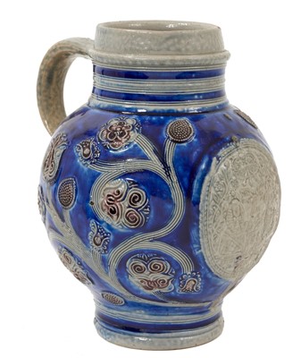 Lot 100 - Rare Westerwald stoneware Royal jug, with roundel containing the portraits of William of Orange and Queen Mary, an inscription beneath in Dutch dated 1691, on a blue ground with sinuous foliate...