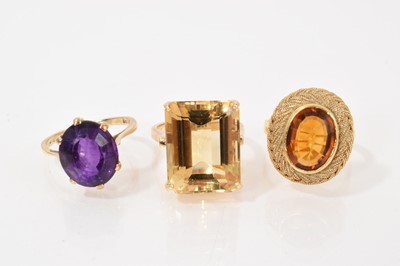 Lot 439 - Three gold and single stone dress rings to include two citrine rings and an amethyst ring