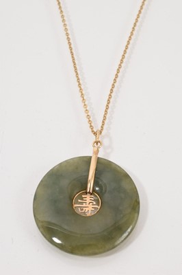 Lot 534 - Chinese green jade bi pendant in a 14ct gold mount on 14ct gold chain