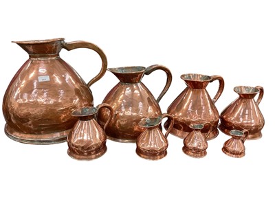 Lot 864 - Graduated set of eight copper harvest jugs