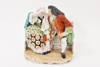 Lot 139 - Large 19th century continental porcelain group showing a couple seated on a bench, the gentleman helping to remove something from the lady's eye