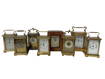 Lot 657 - Collection of eight Edwardian and later carriage clocks in brass cases including Edwardian example in carrying case, modern example in gilt brass case with painted porcelain panels 18cm