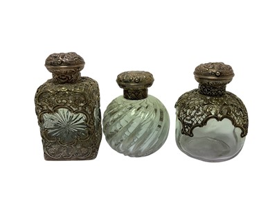 Lot 315 - Three late Victorian silver mounted glass scent bottles by William Comyns