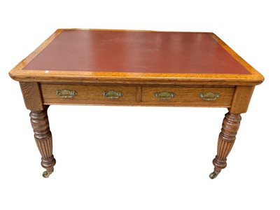 Lot 5385 - Early 20th century oak writing desk by 'Selbat', with two drawers, red leather top, fluted baluster legs and brass casters, 121cm wide x 89cm deep x 74cm high