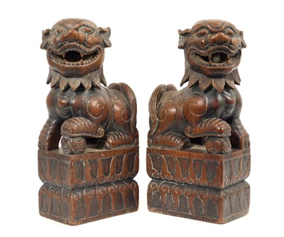 Lot 692 - Pair of late 19th / early 20th century carved hardwood temple lions, 27cm high