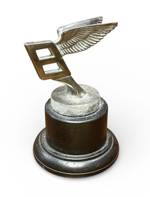 Lot 14 - Bentley Flying B mascot with silver plated finish on milled edged base and turned wood display plinth. Believed to be a 1950s factory long service / retirement gift 9.75 cm high overall