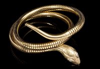 Lot 458 - Gold (9ct) snake bangle, the coiled gold body...