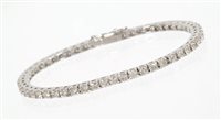 Lot 537 - Diamond tennis bracelet with a continuous line...