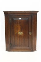 Lot 1443 - George III oak hanging corner cupboard with...