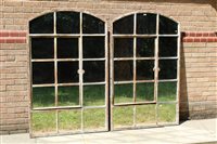 Lot 1384 - Pair of arched mirrored panels, each with...