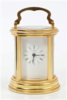 Lot 1257 - Contemporary gilt brass carriage clock in oval-...