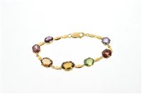 Lot 603 - Gold and multi-gem set bracelet with a line of...