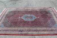 Lot 1397 - Large Persian style carpet, brick-red field...