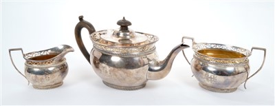 Lot 439 - Edwardian silver three piece tea set - comprising teapot of oval bellied form, with engraved monogram, gadrooned borders and pierced rim, fruitwood loop handle