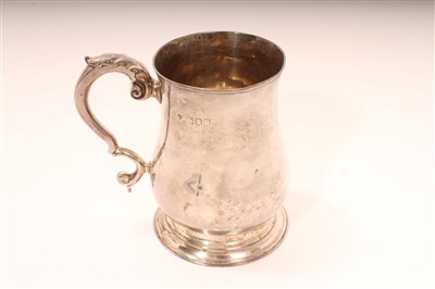 Lot 441 - Edwardian silver mug of baluster form, with leaf mounted scroll handle, on a circular base (London 1902), Holland, Aldwinckle & Slater.  All at approximately 6ozs, 10cm overall height