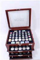 Lot 125 - U.S. a teak three-drawer cabinet with glass hinged top, containing ‘The World War II U.S. Coin 75th Anniv. Collection, with Certificates of Authenticity (qty)
