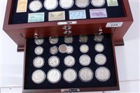 Lot 125 - U.S. a teak three-drawer cabinet with glass hinged top, containing ‘The World War II U.S. Coin 75th Anniv. Collection, with Certificates of Authenticity (qty)