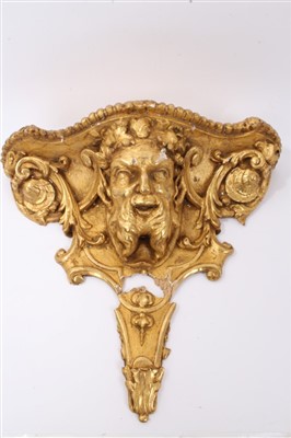 Lot 921 - 19th century gilt giltwood wall shelf, of shaped outline with Bacchus mask ornament, 57 cm wide