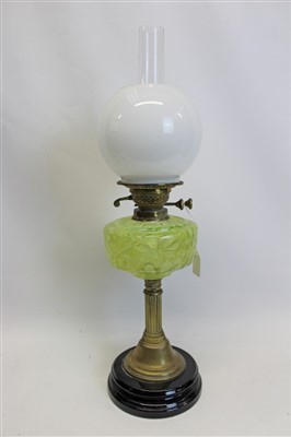 Lot 3504 - Late 19th century oil lamp with ‘English Made’ burner and moulded green glass reservoir, fluted brass column and black ceramic base, clear glass chimney and white globe shade (shade cracked), 65cm...