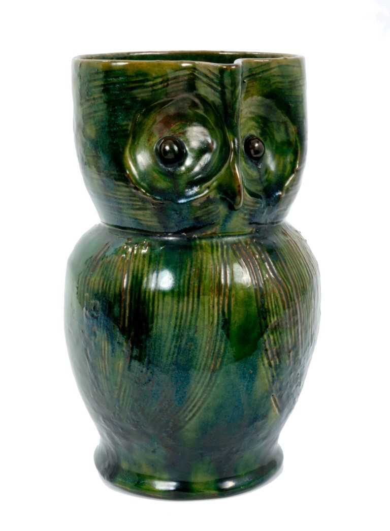 Lot 261 - Late 19th century Farnham pattern pottery owl jug with green and brown glaze and incised decoration