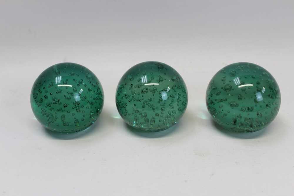 Lot 2133 - Three Edwardian green glass paperweights with bubble decoration