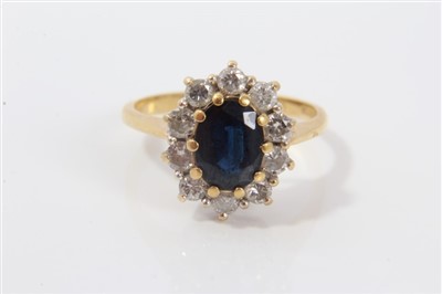 Lot 3285 - Gold (18ct) sapphire and diamond cluster ring