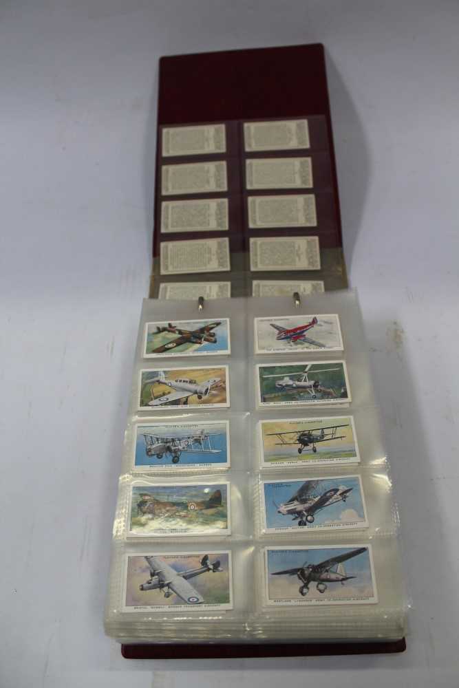 Lot 54 - Cigarette cards - selection in album and loose - including Ardath Britains Defenders, Wills Merchant Ships of the World, plus other trade and reproduction issues, postcards - including Nostalgia, etc