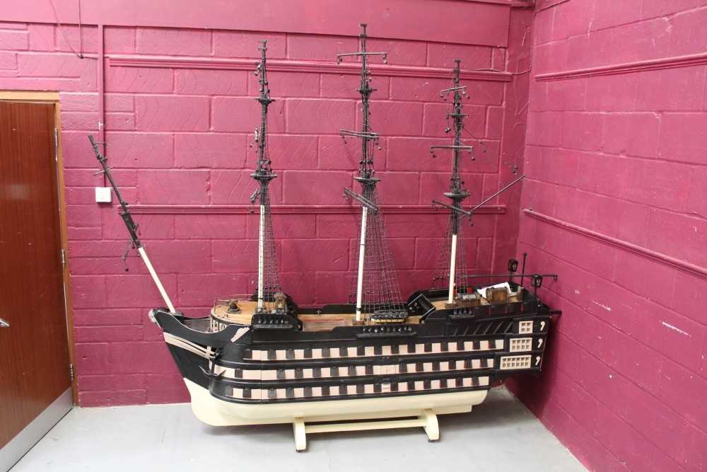 Lot 1070 - Very large and impressive old painted wooden model of HMS Victory with removable sides and opening stern